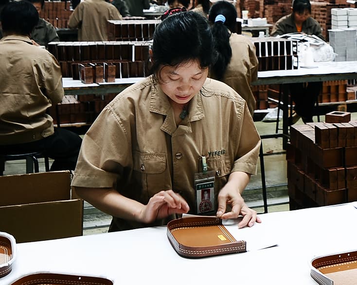 a worker is meticulously hand assembling rigid boxes